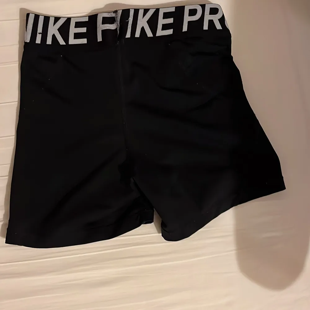 Säljer ett par svarta Nike Pro träningsshorts i mycket bra skick. De är högmidjade med en elastisk midja och har en liten vit Nike-logga på benet. Perfekta för gymmet eller löprundan!. Shorts.