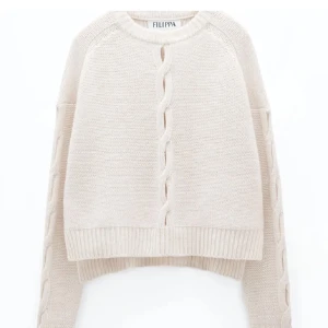 Vit stickad tröja från Filippa K - Säljer en superfin beige stickad tröja från Filippa K. Den har en snygg flätad detalj framtill och på ärmarna.  Perfekt för höst och vinter! Nypris ca 3000, ull och Kashmir 
