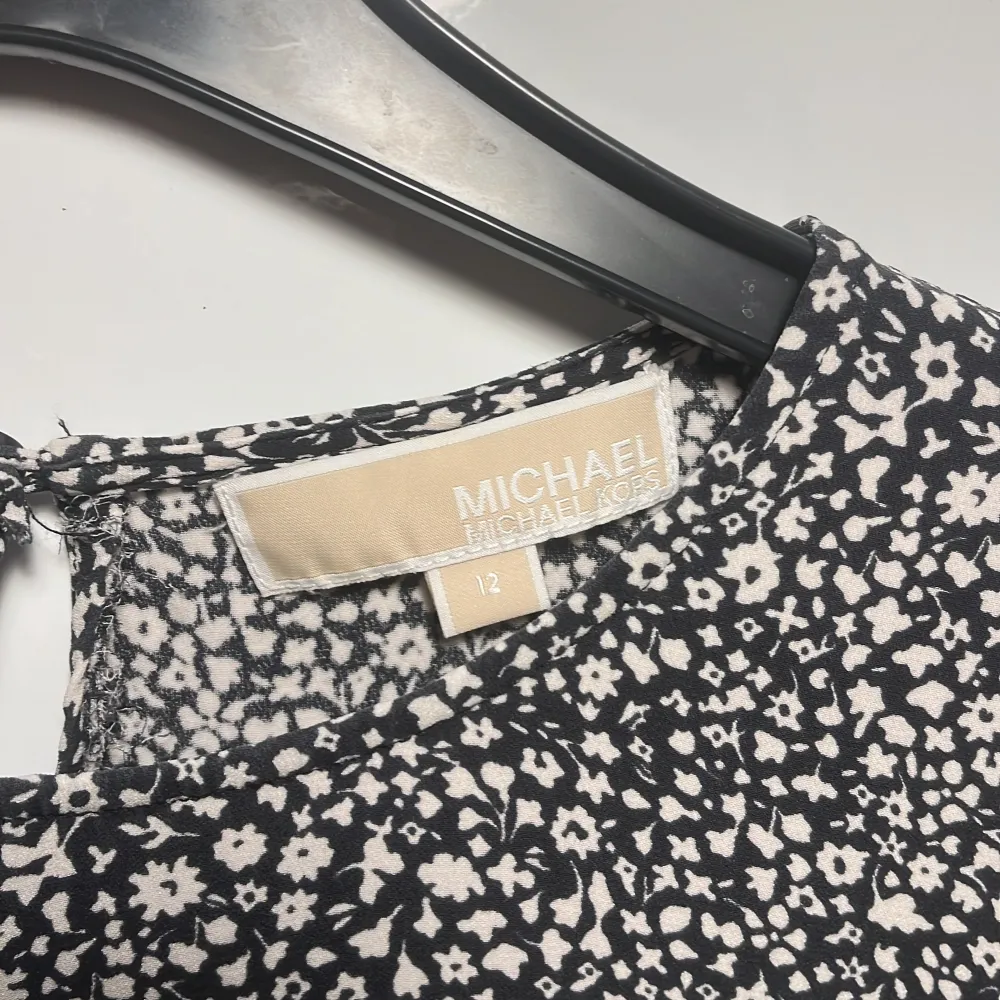 Säljer en superfin blommig klänning från Michael Kors i svart och vitt. Den har korta ärmar och en bekväm passform som passar perfekt för både vardag och fest. Klänningen är i mycket bra skick och har ett diskret blommönster som ger en stilren look.🖤. Mekot.