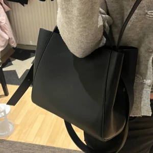 Svart väska  - Svart väska från Gina Tricot, använd 1/2 gånger bara så helt ny! Inga defekter. Långa banden kan tas av, och kan användas som crossbody väska & handväska. Nypris 399!! ❤️