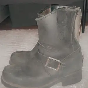 Säljer ett par svarta boots i skinn med coola detaljer som dragkedja bak och ett snyggt spänne på sidan. Perfekta för höst och vinter, de har en robust klack och är i bra skick. Passar både till vardags och lite tuffare outfits.