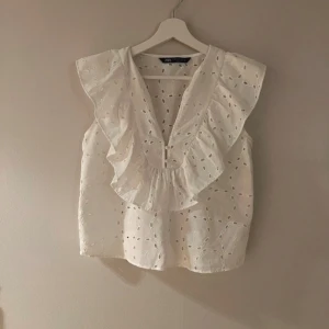 Vit blus från Zara - Säljer en söt vit blus från Zara med volangdetaljer och v-ringning❤️den är tyvärr för liten så kan inte visa hur den sitter på