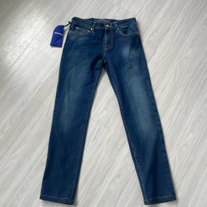 Blå jeans från Jacob Cohën - Snygga blå jeans från Jacob Cohën, kända för sin lyxiga och skräddarsydda design. Tillverkade i Italien med exklusivt utvalt denim. Helt nya och oanvända.