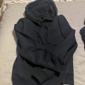 Svart hoodie från H&M - Säljer en svart hoodie från H&M i relaxed fit. Den har en klassisk design med huva och dragsko samt långa ärmar. Perfekt för en avslappnad stil.