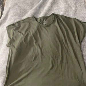 Grön t-shirt från SOC - Säljer en grön tränings t-shirt från SOC i storlek L. T-shirten är kortärmad och tillverkad i ett tekniskt material som håller dig torr och bekväm. Perfekt för träning eller vardagsbruk.
