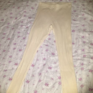 Beige ribbade leggings från H&M - Säljer ett par snygga beigea ribbade leggings från H&M. De är högmidjade och har en tight passform. Materialet är stretchigt! Perfekta för en avslappnad outfit men också till träning tex.