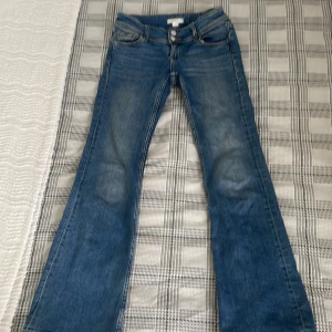 Blå bootcut jeans från Gina Tricot - Snygga blå lowasit bootcut jeans från Gina Tricot i storlek 146 tall. Inte använda så mycket då de vart för små. Fickor med knapp där bak. Nypris 360 kr 