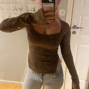 Brun ribbad topp från Gina - Säljer en snygg brun ribbad topp från Gina. Toppen har en fyrkantig urringning och långa ärmar. Perfekt för en stilren look. Passar bra till jeans eller kjol. Den är tyvärr lite liten till mig.