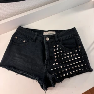 Lågmidjade shorts  - Lågmidjade shorts med silver nitar. Säljer då de är för små för mig. Alla nitar är på plats! Midjemått 36cm längd höjd 20cm
