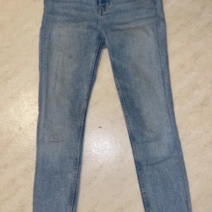 Blå skinnyjeans - Ljusblå skinny jeans med en klassisk femficksdesign. De har en knapp och dragkedja framtill.