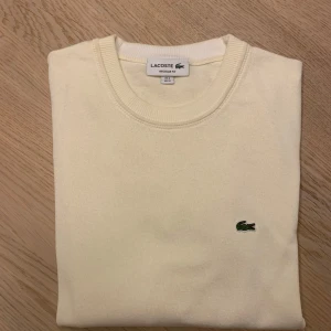Cremevit tröja från Lacoste - Stilren cremevit/offwhite stickad tröja från Lacoste i perfekt skick. 