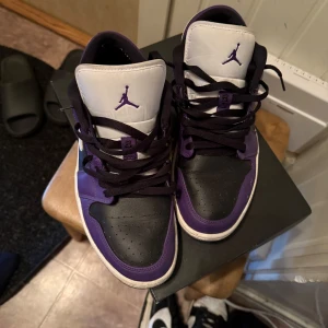 Jordan 1 Low Court Purple - Säljer ett par Nike Air Jordan 1 Low i en snygg kombination av lila och svart med vita detaljer. Skulle säga skicka 7/10 men ni får bedömma själva på bilderna. Vid snabb affär kan priset diskuteras.  