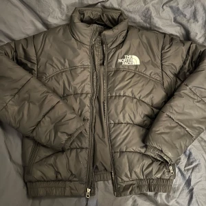 Svart pufferjacka The North Face - Säljer en svart pufferjacka från The North Face i mycket bra skick. Jackan är perfekt för kalla dagar med sin quiltade design och dragkedja framtill. Den har långa ärmar och är gjord i syntetmaterial, vilket gör den både varm och lätt. Passar perfekt för höst och vinter!
