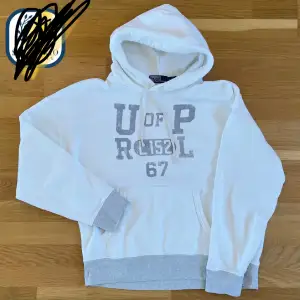 Säljer en snygg vit hoodie från Polo Ralph Lauren med grå text på framsidan. Den har en stor ficka fram och en bekväm huva. Perfekt för en avslappnad stil eller kyliga dagar. Passar både till vardags och chillkvällar.