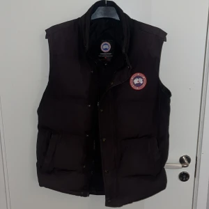Canada goose väst  - Väldigt sliten därpå priset. Jackan har blivit syd på fickorna!