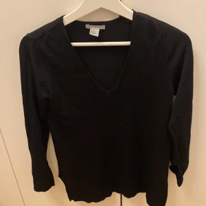 Svart v-ringad tröja - Säljer en stilren svart v-ringad tröja i storlek XS. Perfekt för både vardag och festliga tillfällen. Tröjan har långa ärmar och är i ett mjukt material som känns skönt mot huden. Passar utmärkt till höst- och vintergarderoben.