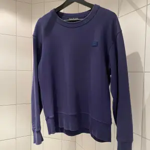 Acne Studios face logo sweatshirt i bra skick. Den är i en mörk lila färg i storleken Small. Nypris är 2000kr+