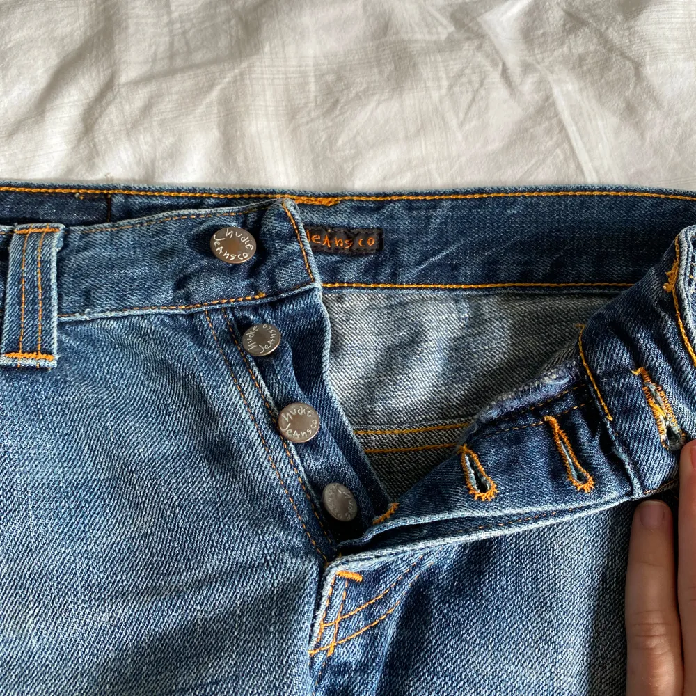 Säljer dessa skitsnygga lågmidjade jeans från Nudie jeans company då de inte kommer till användning. Vet ej va de e för storlek på dom. Midjemått rakt över: 41 cm. Innerbenslängd: 86 cm. . Jeans & Byxor.