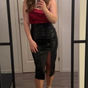 Svart kjol med röd topp  - Säljer både svarta kjolen och den röda toppen.  Kjolen har storlek 38 Toppen har storlek 40