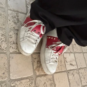 Valentino skor - Röda valentino skor med nitar. Nypris 8515 kronor. Köpta från valentinos offeciella hemsida. Har extra snören som är nya och rena om man vill byta till dom så skorna ser nyare ut. 