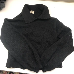 Svart stickad tröja - Säljer en snygg svart stickad tröja. Den har en klassisk krage och långa ärmar. Perfekt för höst och vinter, och den är i nyskick. Supermjuk och bekväm att ha på sig!