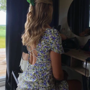 Blommig klänning - Kort blommig klänning med snörning i ryggen. 