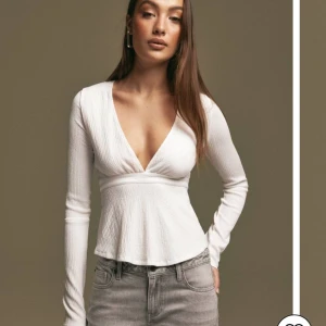 Långärmad topp - Supersnygg vit långärmad topp med v ringning och snörning i bak! Från Nelly, oanvänd 