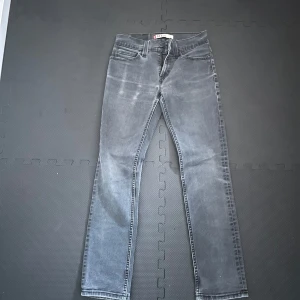 Grå Levis 511 jeans - Säljer ett par snygga grå Levis 511 jeans. De är i slim fit och har en klassisk femficksdesign. Jeansen är i bra skick och har en cool tvättad look. Perfekta för både vardag och fest!