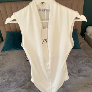Ny Zara vit body, S -  Vit body med djup V-ringning och knappar i grenen. Snygg och bekväm passform. Ny med lappen kvar.  #sexy #sexig #snygg #body Pris:120 kr 🚭Djurfritt och rökfritt hem  📍Kan mötes upp i Mölnlycke centrum 📮Kan skickas mot fraktkostnad