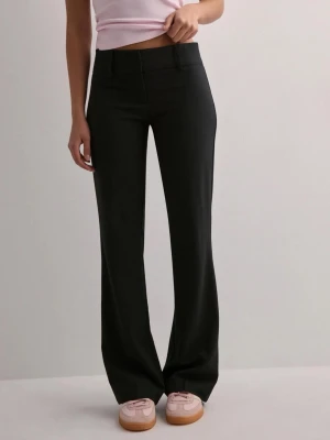 Svarta kostymbyxor  - Säljer ett par svarta kostymbyxor från Nelly med låg midja och bootcut. Byxorna har bälteshällor och diskreta fickor framtill. Perfekta för en clean och stilren look. Materialet är mjukt och har ett snyggt fall. Aldrig använda och med prislapp kvar. Går ej att få tag på längre