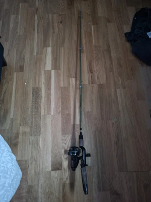 Fiskespö med rulle Abu Garcia Cardinal - Fiskespö med svart och guldfärgad rulle från Abu Garcia, modell Cardinal 5A. Spöt har korkhandtag och svart metallfäste. Perfekt för dig som gillar fiske och vill ha ett klassiskt spö med stabil känsla. Silver grejen enda som har lossnat från ena sidan se bild. Mycket eftertraktad 
