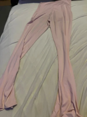 Ljusrosa leggings med utsvängda ben - Säljer ett par ljusrosa leggings med utsvängda ben. De är mjuka och stretchiga, perfekta för en avslappnad och trendig look. Materialet känns bekvämt mot huden och färgen är superfin till många outfits.