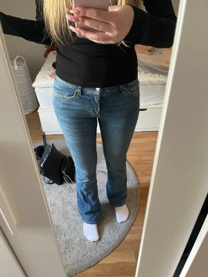 Blåa jeans - Säljer dessa mid waist bootcut jeans från Gina tricot. Dem är ganska stretchiga i materialet. Storlek 34, använda ganska mycket men fortfarande super fint skick. Jag är 168cm och dom går typ en cm till marken på mig.