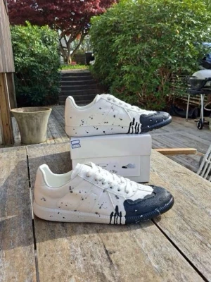 Maison Margiela skor blå färg - Unika vita sneakers från Maison Margiela med marinblå tå detaljer och färgstänk över hela skon.                                            Helt nya storlek 43 tillbehör och kvitto finns!