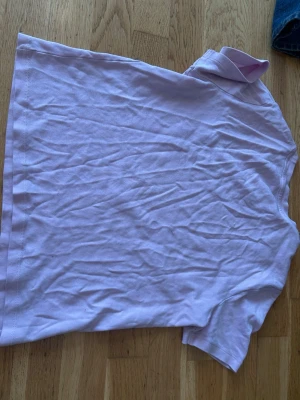 Ljuslila basic t-shirt - En enkel och stilren ljuslila t-shirt i mjuk bomull. T-shirten har rund halsringning och korta ärmar, perfekt för en avslappnad look. Passar till det mesta och är lätt att matcha med jeans eller shorts.
