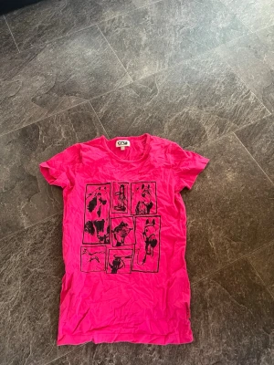 Rosa t-shirt med hundmotiv från CRW - Cool rosa t-shirt från CRW med svart tryck av olika hundar på framsidan. T-shirten har rund hals och korta ärmar, perfekt för en avslappnad och trendig stil. (Plus frakt) 