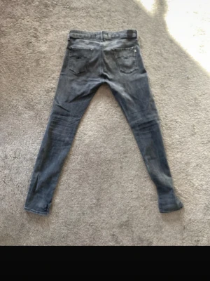Replay jeans - Säljer ett par grå slim fit jeans med klassiska bakfickor och diskreta sömmar. Jeansen har en tvättad look och smala ben, perfekta för en avslappnad och trendig stil. Materialet känns mjukt och följsamt, vilket gör dem bekväma att bära hela dagen om du är intresserad är de bara skriva för mer bilder eller annat dom är små i storlek 
