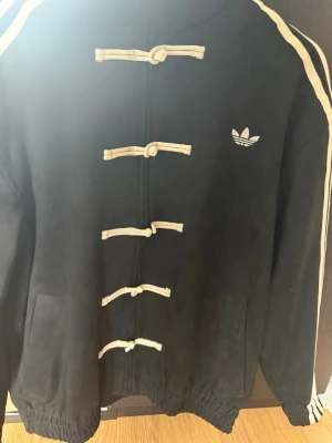 Adidas Original Tang jacka - Extremt ovanlig jacka från Adidas Originals som endast finns tillgänglig i Kina. Begränsad utgåva och mycket svår att få tag på i Sverige och övriga Europa. För dig som vill sticka ut med ett plagg som nästan ingen annan har. Köpte denna efter att ha varit i Shanghai i drygt 2 veckor. Finns även i andra färger och storlekar. Priset går att diskutera vid smidig affär eller vid köp av fler produkter. Jackan finns i storlek S och M men passar även till storlek M och L.