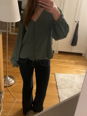 Mörkblå bootcut jeans  - Säljer ett par mörkblå bootcut jeans med vita kontrastsömmar och låg midja. Jeansen har klassisk femficksdesign och är tillverkade i ett stretchigt denimtyg som sitter snyggt. Perfekta för dig som gillar en tidlös och avslappnad look. Väl använda men inga defekter som jag ser.
