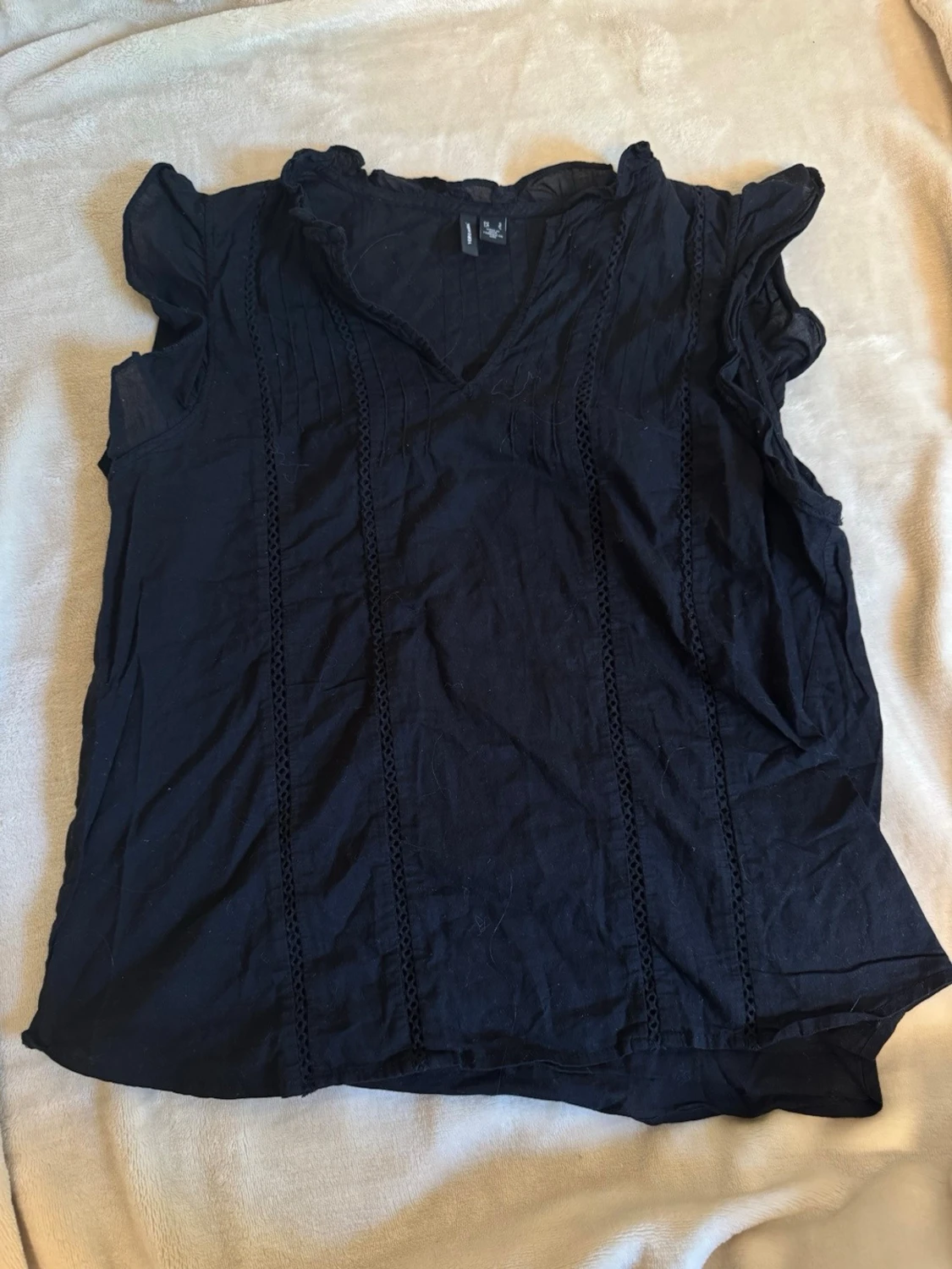 Svart ärmlös blus med volang