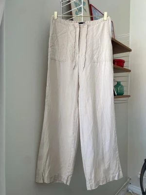 Vintage linnebyxor  - Linnebyxor i beige. Strl 32/34. Några noppror på ena byxbenet baktill (se sista bild), i övrigt fint skick!
