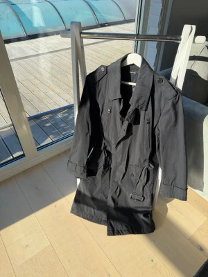 Stilren trenchcoat från Matinique – storlek S 🖤 - Säljer en snygg och tidlös trenchcoat från Matinique i klassisk svart färg. Perfekt jacka för både vardag och mer uppklädda tillfällen.  ✔️ Storlek S ✔️ Bra skick ✔️ Elegant och stilren modell ✔️ Svart – passar till allt ✔️ Finns i djur- och rökfritt hem  En perfekt jacka nu till vår, höst och svalare dagar. Säljes då den inte längre kommer till användning.  Kan skickas eller hämtas enligt överenskommelse.