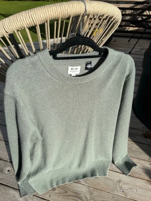Ljusgrön stickad tröja från No 10 - Snygg ljusgrön stickad tröja från No 10 med rund halsringning och ribbade muddar. Perfekt för lager-på-lager och enkel att matcha med jeans eller kjol. Mjuk och skön känsla, passar dig som gillar stilrena plagg.