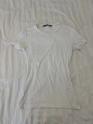 Vit t-shirt  - En enkel vit t-shirt från lager 157 i storlek XS. T-shirten har rund halsringning och korta ärmar. Tillverkad i mjuk bomull för en skön känsla och passar perfekt till alla typer av outfits.