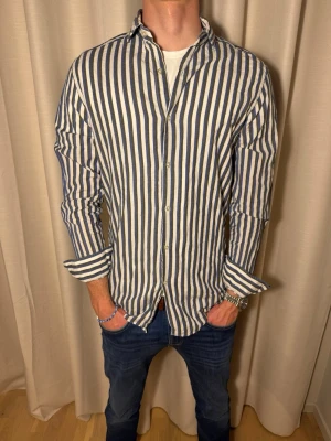Randig linne skjorta  - Tjena hörni! Vi säljer denna randiga linne skjortan från märket Massimo dutti i storlek M för endast 399kr. Skjortan har inga tecken på användning och nypris ligger på cirka 900kr. Skicket är 10/10. Hör av er vid frågor eller prisförslag💙💙// studio II Resell 💪