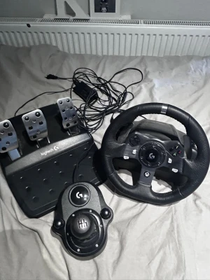 Logitech g920 - Jätte fin logitech g920 ratt,pedaler,växellåda perfekt för dig som vill spela realistiska bil,lastbilsspel osv nypris för ratt och pedaler=2300kr. Växellåda=700kr. Jag har även justerat bromspedalen för att vara så realistisk som möjligt. Allt är i sin ordning inget glapp i någon kabel alls. De ända negeativa är att de sport växelpadlarna på ratten på höger sida funkar hälften av tiden men de är nog relativt lätt fix skulle gissa på att de bara är att öppna den och kolla om nån kabel är lös.