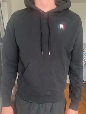 Svart hoodie från AMI Paris - Snygg svart hoodie från AMI Paris med broderad logga i vitt, blått och rött på bröstet.