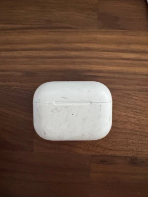 Apple AirPods Pro 2 - Trådlösa vita in-ear hörlurar från Apple, modell AirPods Pro, med silikonproppar och tillhörande vitt laddningsetui i plast. Smidig design och kompakt format, perfekt för musik och samtal på språng.Ena hörluren har en liten spricka i sig och andra fungerar bara touchen inte ljudet. De finns synliga repor osv (se bilderna). Har hyfsat batteri tid skulle säga 3-4 timmar i örat och med uppladdning osv. Säljs i befintligt skick.