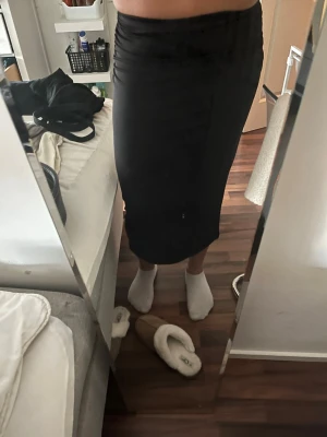 Svart långkjol  - Säljer en svart långkjol med tight passform. Kjolen är enkel och stilren, gjord i ett stretchigt material som sitter snyggt mot kroppen. 
