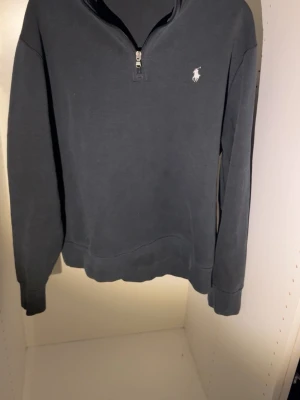 Polo Ralph Lauren quarter zip - Svart långärmad quarter zip-tröja från Polo Ralph Lauren. Tröjan är perfekt nu för de kommande sommar kvällar. En defekt(kolla bild). Skriv privat för mer bilder eller info.